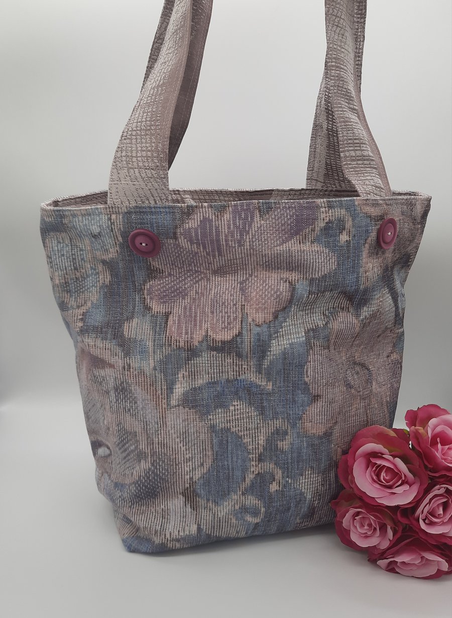 Soft floral lilac and blue handbag with pockets and decorative buttons.  