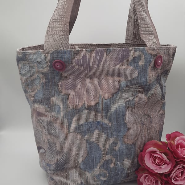 Soft floral lilac and blue handbag with pockets and decorative buttons.  