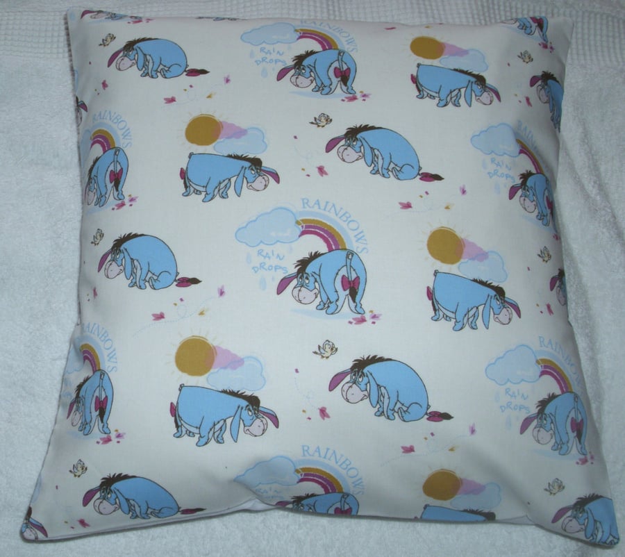  Eeyore sitting, standing, bending over looking at Rainbows cushion