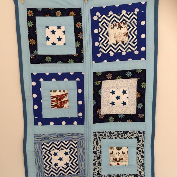 Seconds Sunday. Cotton cot quilt in shades of blue with soft bamboo inner.