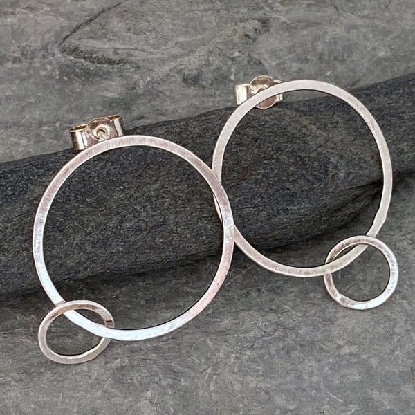Large silver hoop earrings with a matt satin finish or a hammered finish