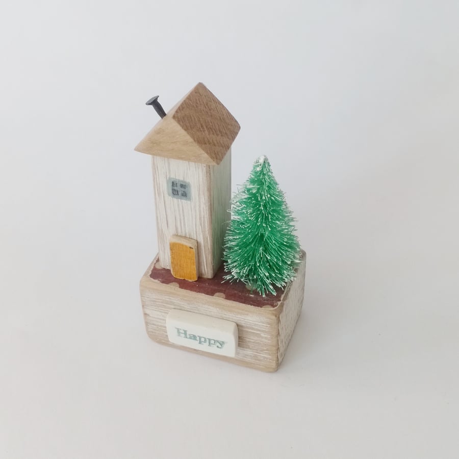 Little wooden house with Christmas tree 'happy'