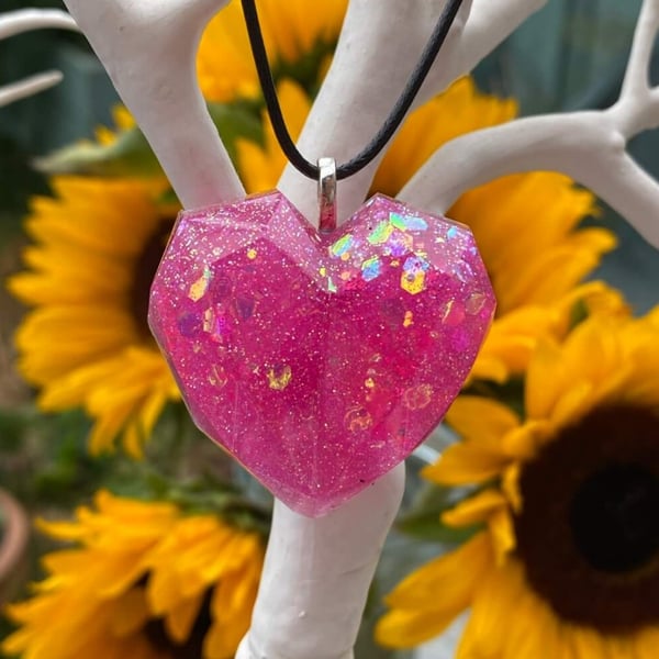 Pink glitter heart pendant on black cord chain.