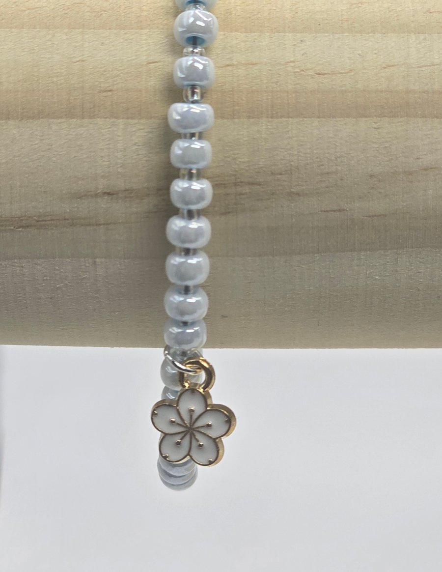 Pearl blue seed bead bracelet with small white flower charm