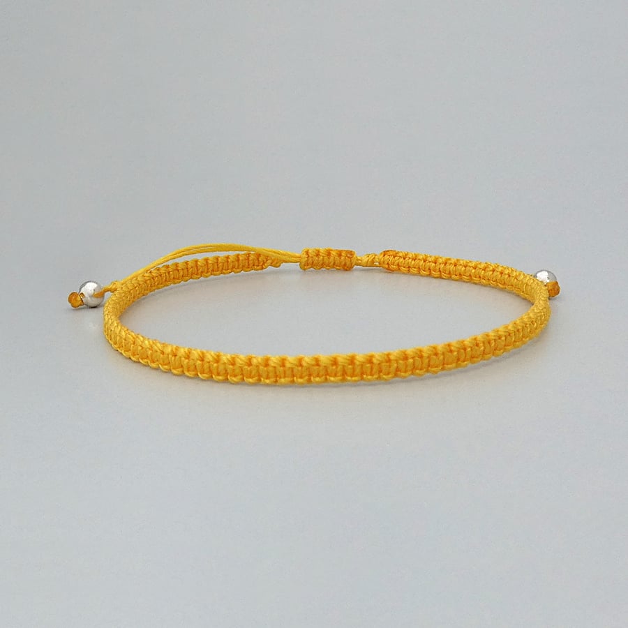 Yellow macramé bracelet with silver plated bead ends. Extends from 7” to 9.5