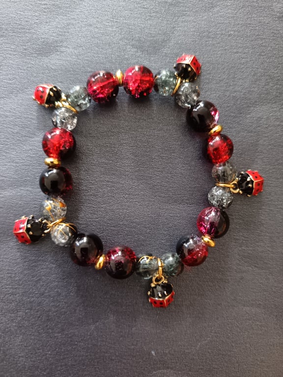 Elasticated red, black and gold beaded ladybird charm bracelet 
