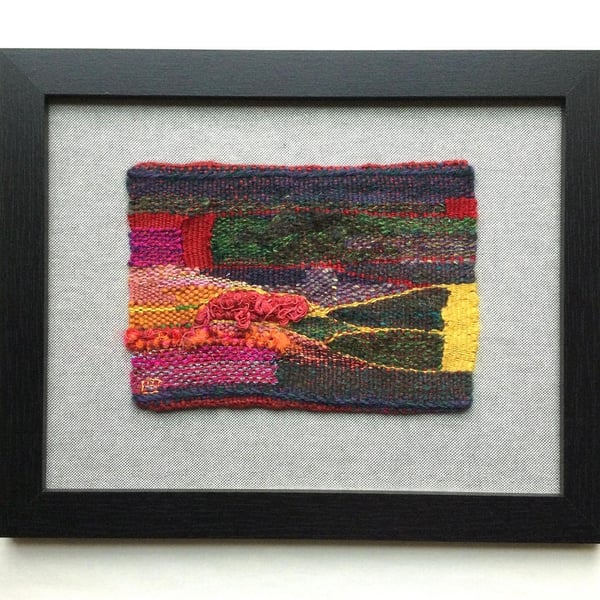 Framed handwoven tapestry weaving, textile in green, yellow, red and pink