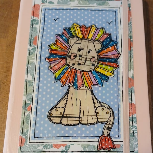 Quirky art A5 lined hardbacked notebook, hand decorated whimsical rainbow lion.
