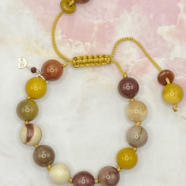 Knotted gold cord bracelet with mookaite stones and silver plated charm
