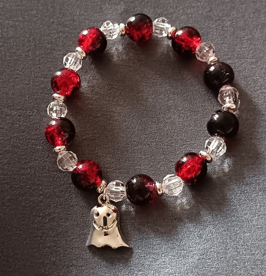 Elasticated red, black and clear beaded bracelet with silver ghost charm