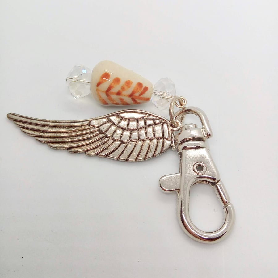Cream Beaded Bag Charm with a Crystal and An Angel Wing Charm