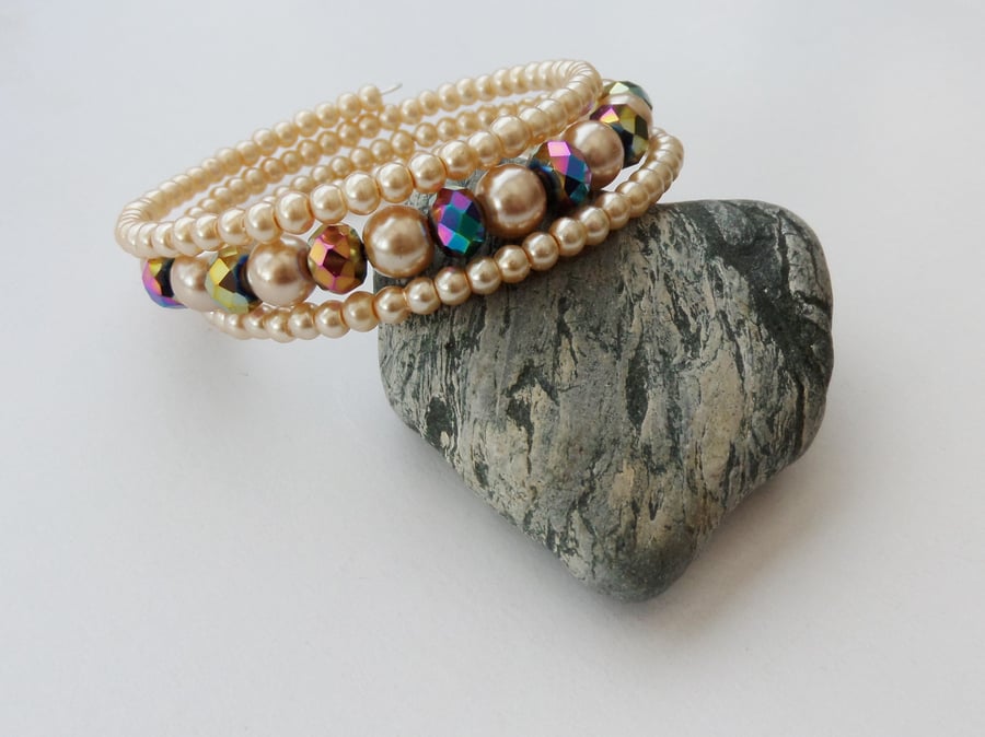 Multicoloured crystal rondelle and pale gold glass pearl memory wire bracelet.