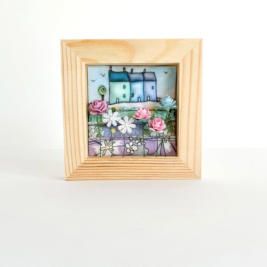 Little blue 3D houses with flowers, in a small frame