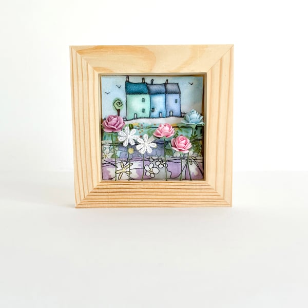 Little blue 3D houses with flowers, in a small frame