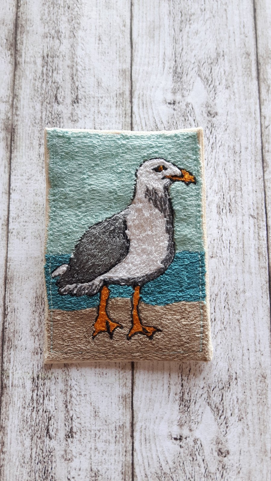 Brooch stitched gull on the beach.