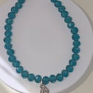 Triskelion charm bracelet with teal faceted beads