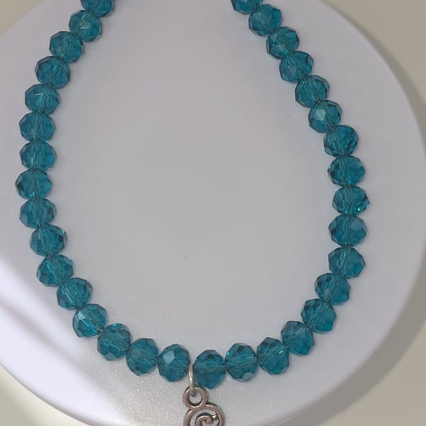 Triskelion charm bracelet with teal faceted beads