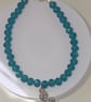 Triskelion charm bracelet with teal faceted beads