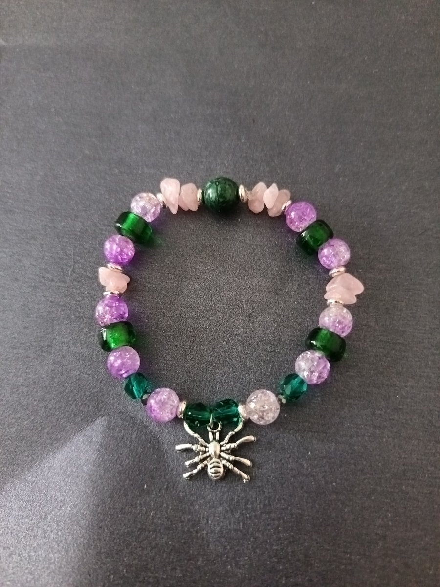 Elasticated purple and green beaded bracelet with silver spider charm