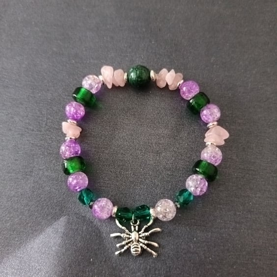 Elasticated purple and green beaded bracelet with silver spider charm