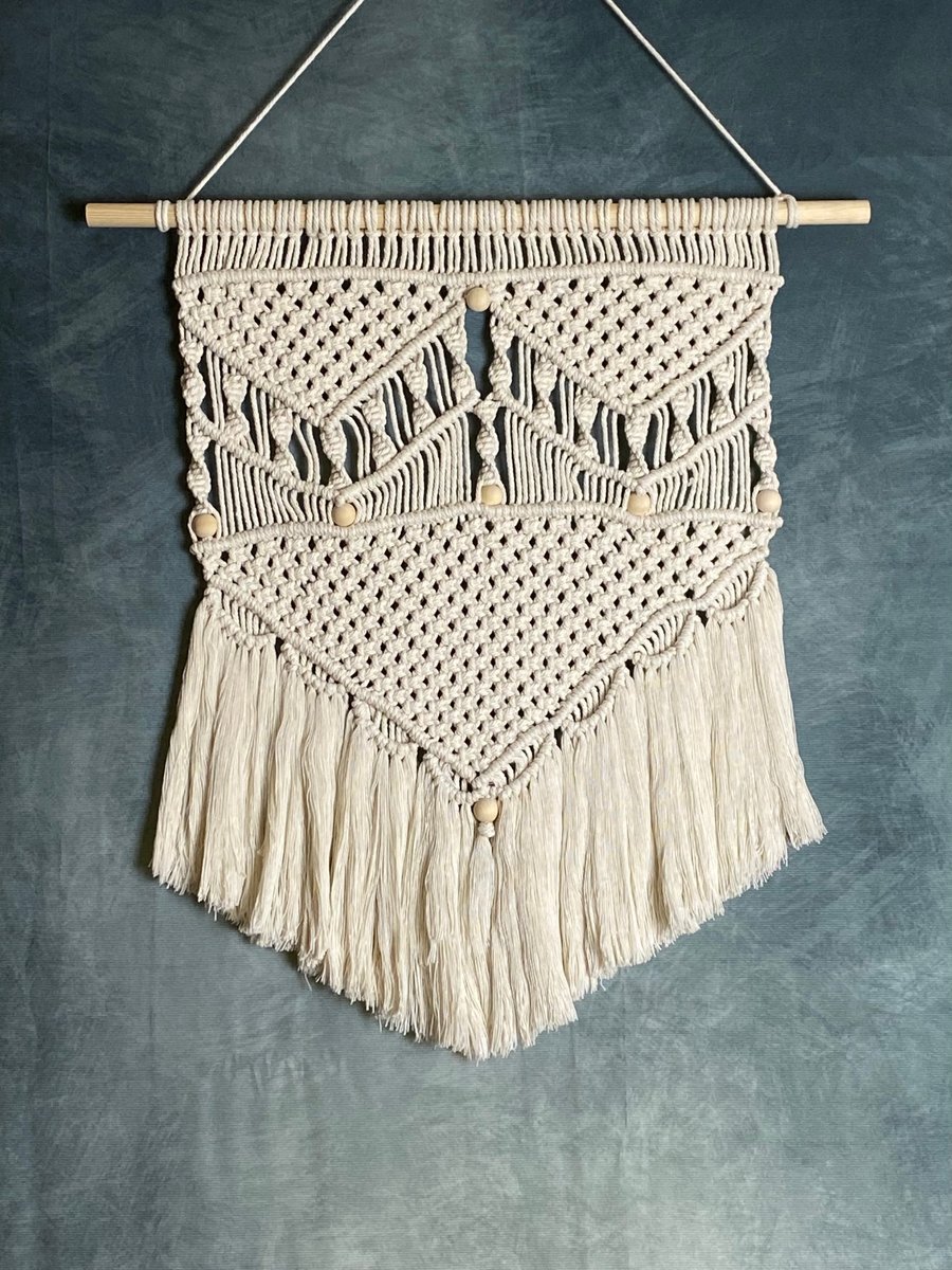 Macrame wall hanging with intricate knot design and wooden beads