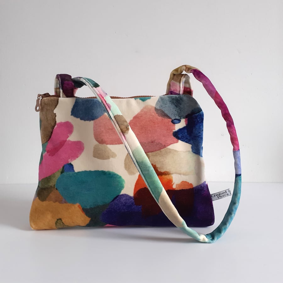 Velvet shoulder bag in a jewel like watercolour print with chunky zip closure.