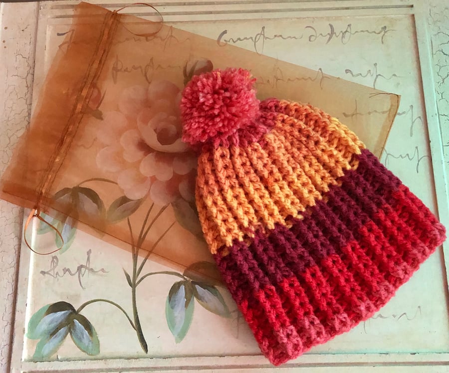 Womens warm bobble hat in "sunset" shade.