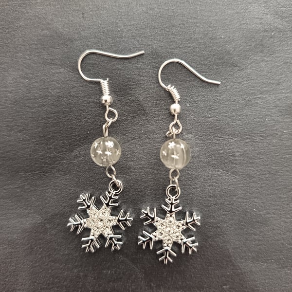 Silver snowflake charm earrings with star bead detail