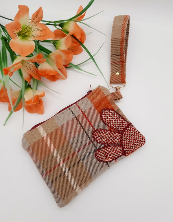 Check clutch bag with clip on handle and flower applique. 