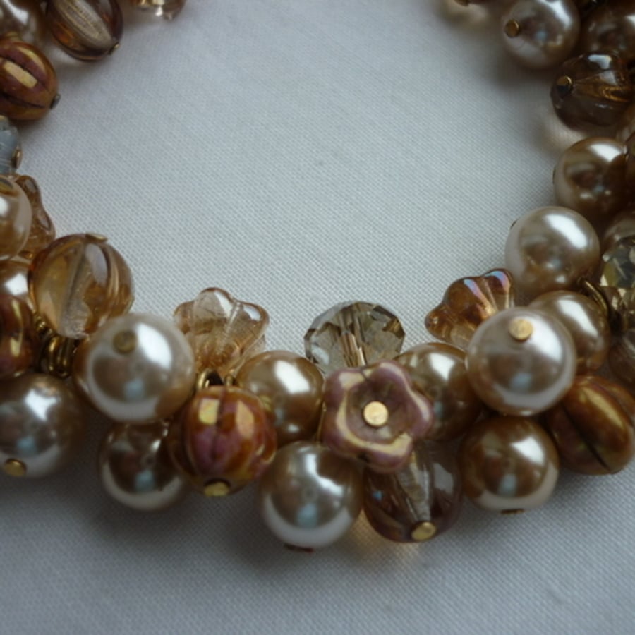 SHADES OF CREAM AND GOLD CLUSTER BRACELET.  150