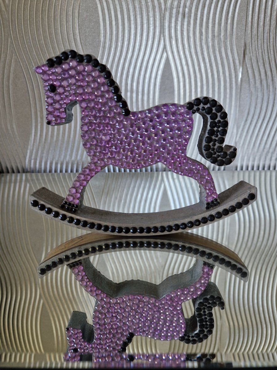 Purple sequinned wooden rocking horse. 