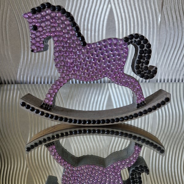 Purple sequinned wooden rocking horse. 