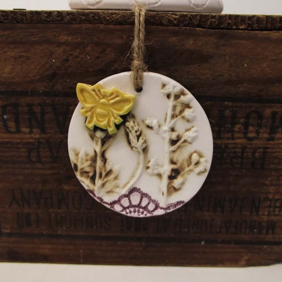 Pottery decoration with natural flower and bee motif.