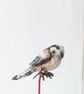 Tiny needle felt bird long-tailed tit in a glass jar