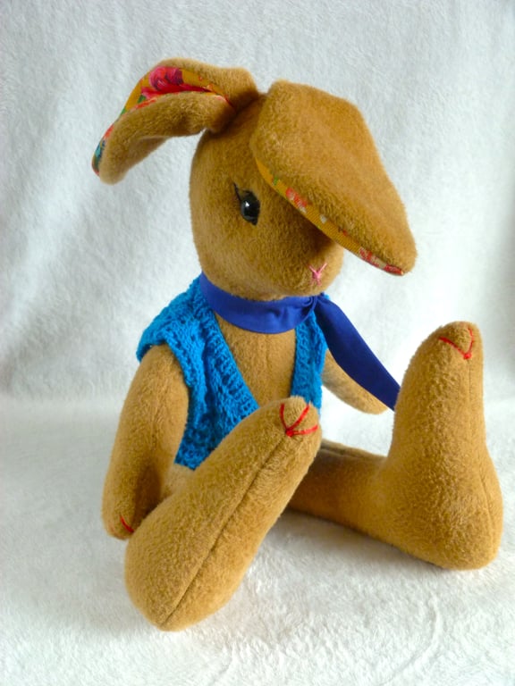 Lupin, a 16" fleece unjointed rabbit with neckerchief and knitted waistcoat.