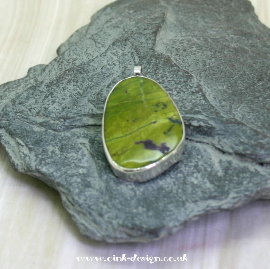 Zoisite gemstone pendant set in a sterling silver open back setting