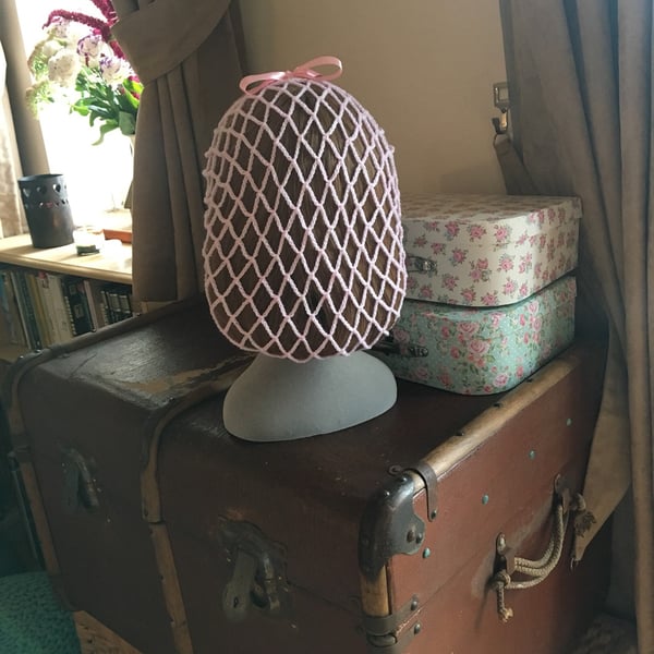 Pale pink 1940s style snood hairnet with a pink ribbon for an authentic vintage 