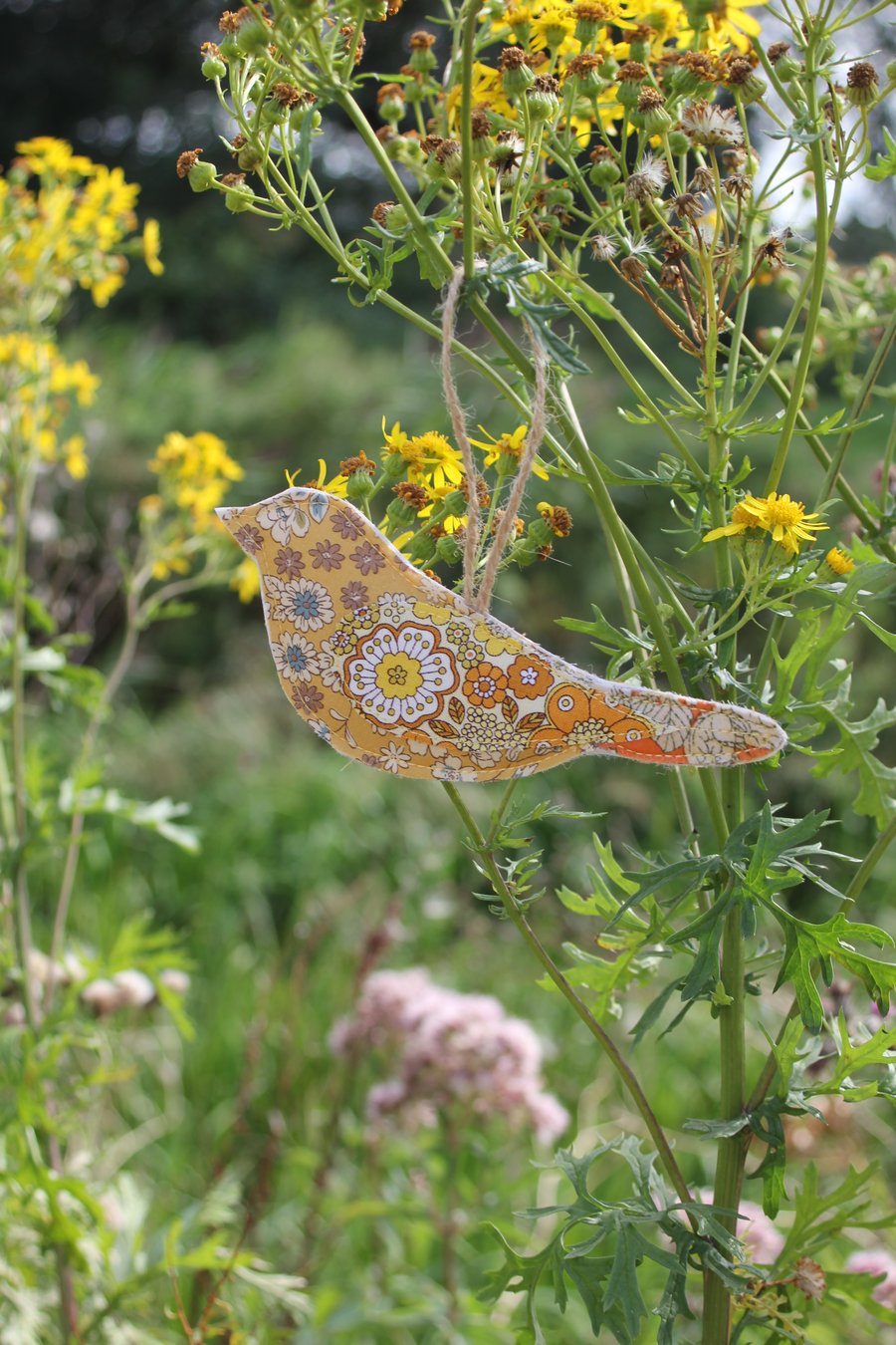 Recycled fabric hanging bird decoration in shades of mustard and orange florals