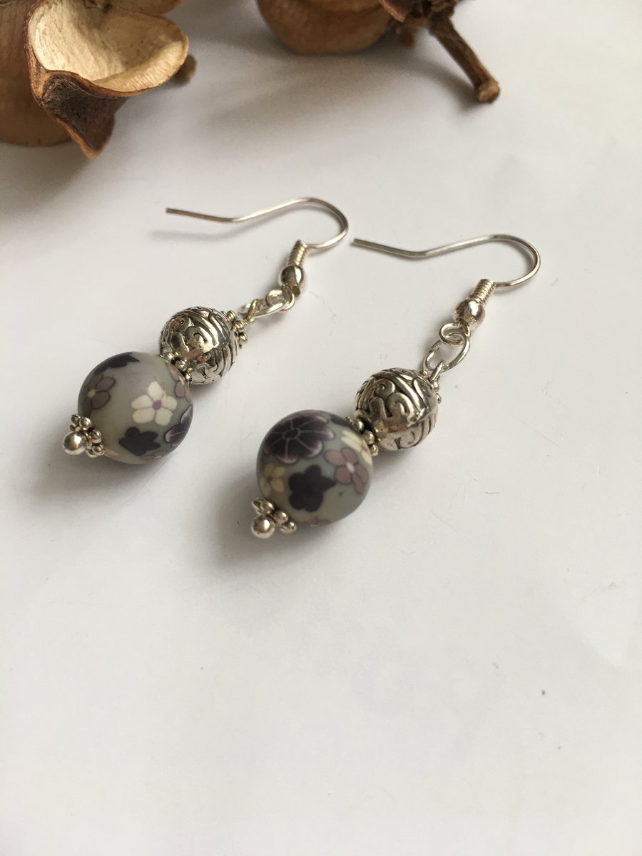 Dangle earrings with grey floral polymer clay beads and silver plated ear wires.