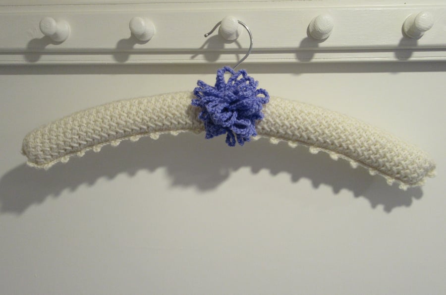 Ladies knitted coat hanger with a large allium flower