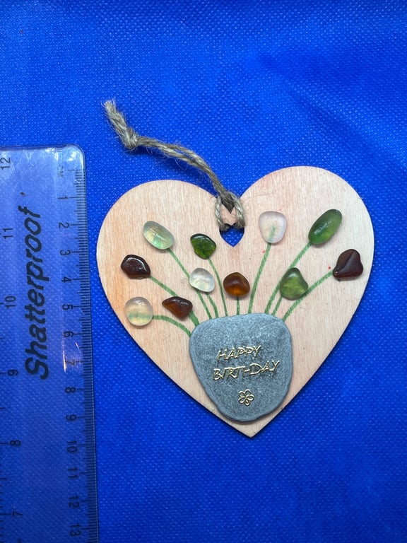 Wooden heart with 'happy birthday' sentiment made using  with sea glass.
