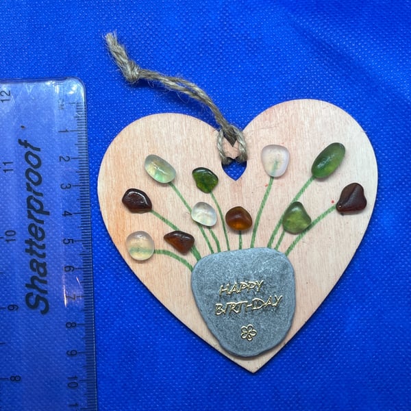 Wooden heart with 'happy birthday' sentiment made using  with sea glass.