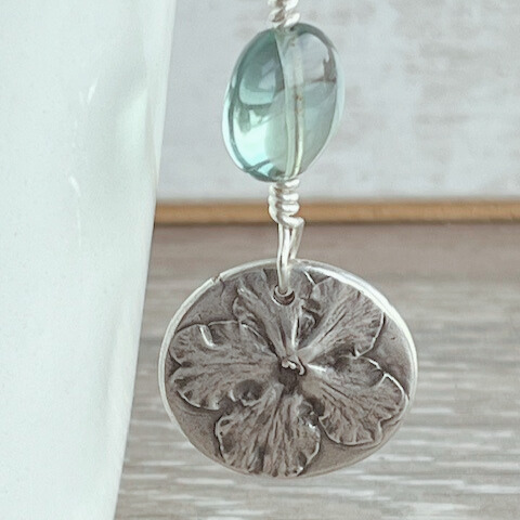 Botanical silver pendant with fluorite bead.