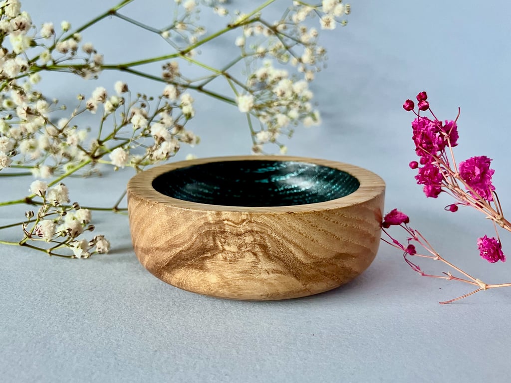 Small, hand-turned wooden dish with vibrant aqua grain detail.