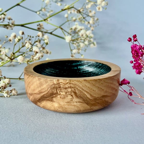 Small, hand-turned wooden dish with vibrant aqua grain detail.