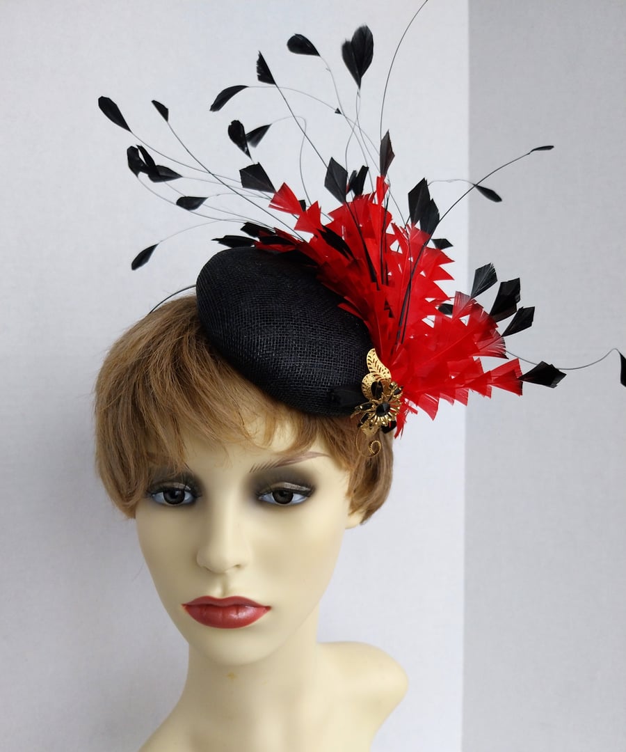 Dorothy Black button shape with a flurry of red and black feathers