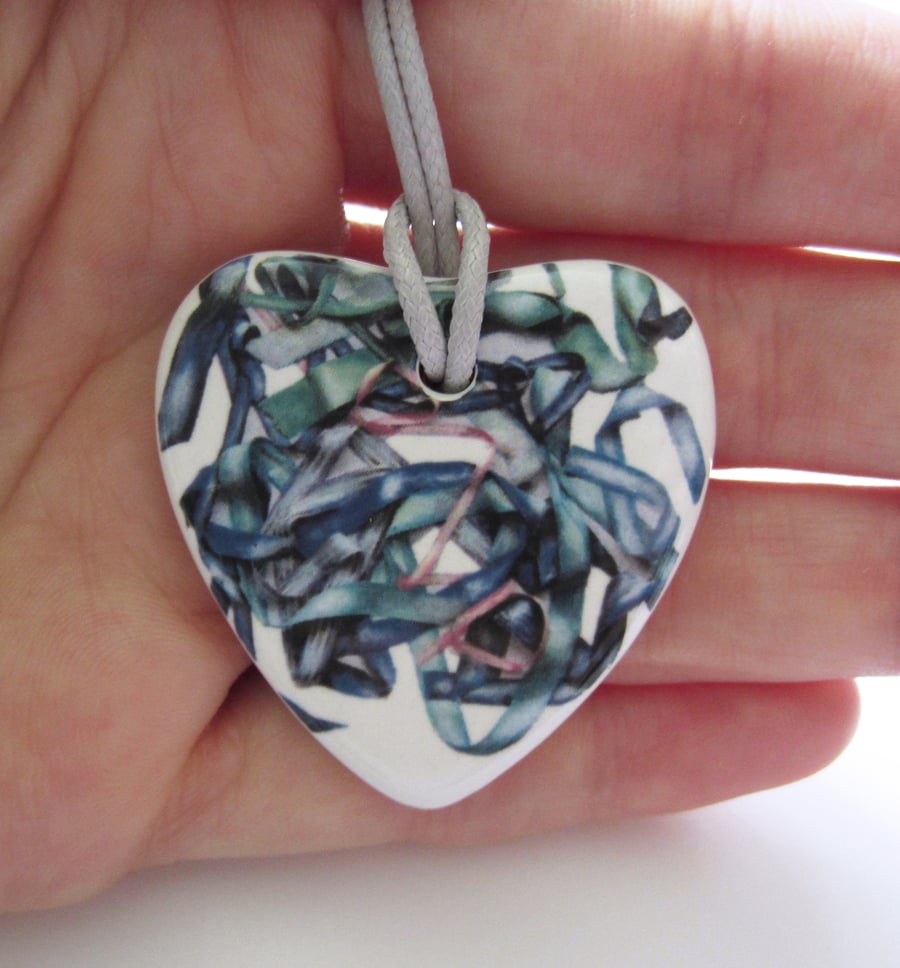 Tousled Ribbon Pattern Heart Shaped Ceramic Pendant on Grey Cord with Clasp