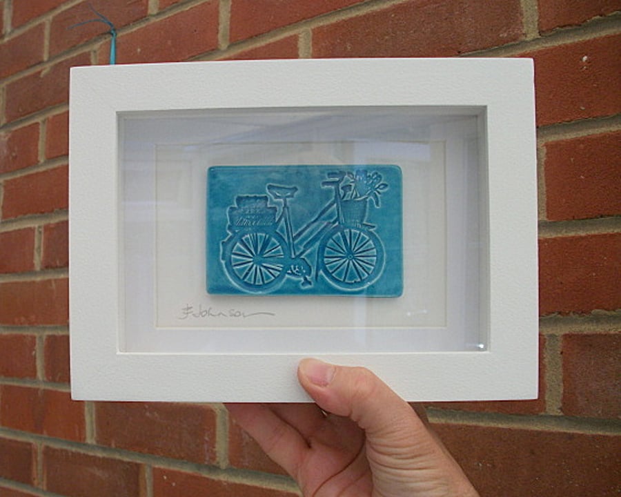 Turquoise ceramic plaque picture impressed with a bike design -
