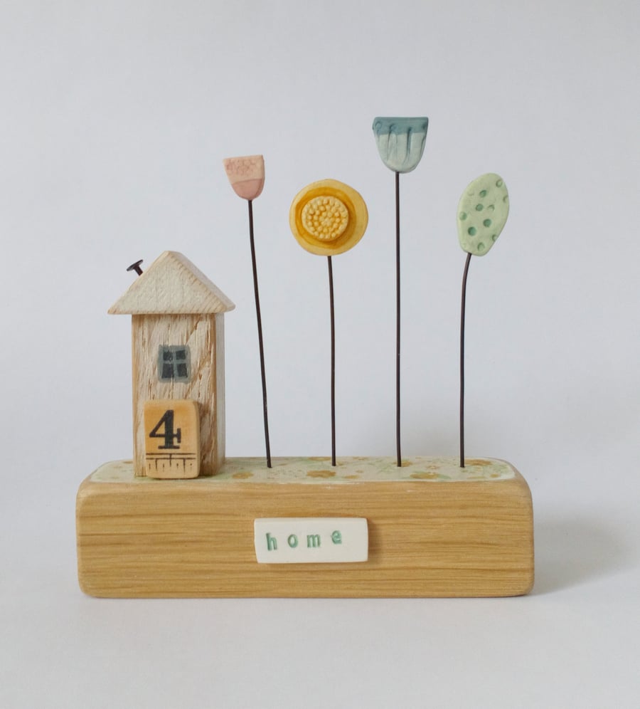 Little wooden house with clay flower garden 'home'