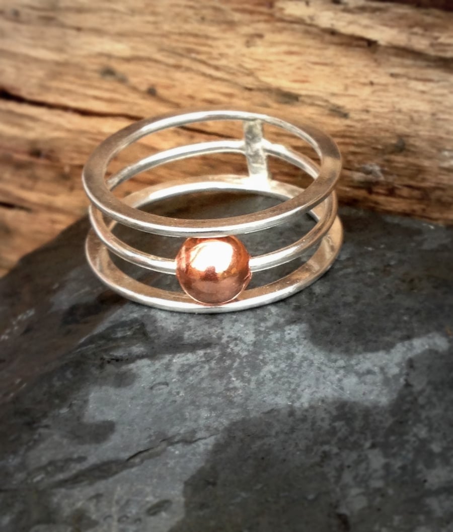 A sterling silver Kinetic ring with moveable solid copper bead. 